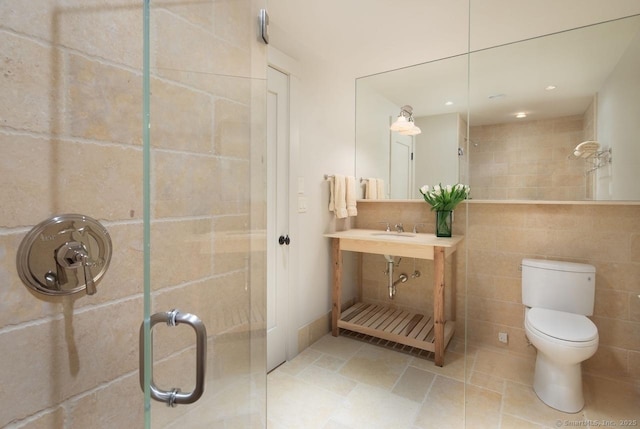 full bathroom with recessed lighting, a shower stall, tile walls, toilet, and a sink