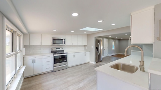 8 Batt St, Middletown, CT 06457 - kitchen featuring a sink, decorative backsplash, light wood-style flooring, a skylight, and appliances with stainless steel finishes