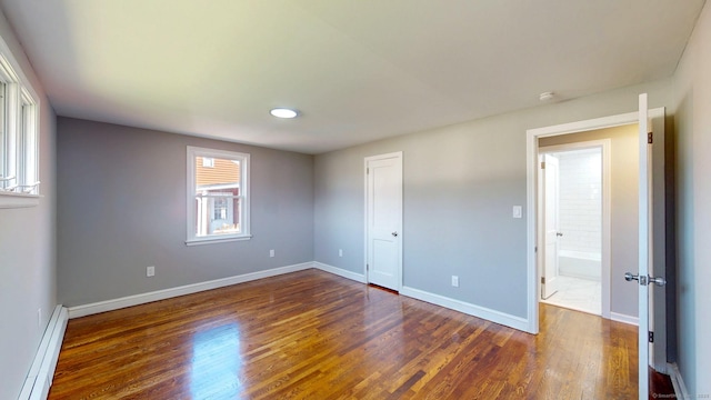 8 Batt St, Middletown, CT 06457 - unfurnished bedroom featuring baseboard heating, baseboards, multiple windows, and dark wood finished floors