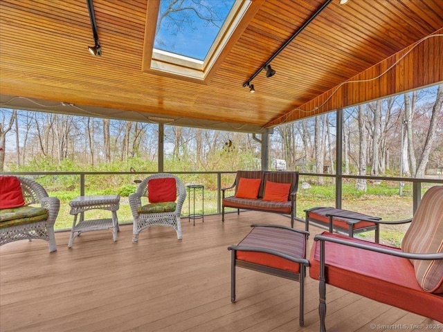 sunroom / solarium with a skylight, rail lighting, and plenty of natural light