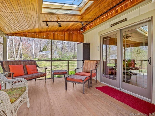 sunroom / solarium with an outdoor hangout area, a skylight, and track lighting