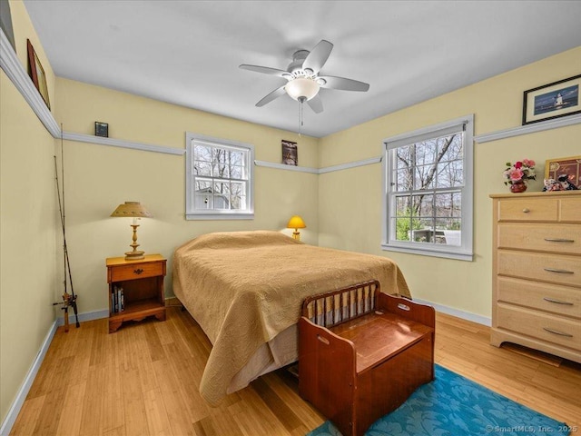 bedroom with wood finished floors, a ceiling fan, and baseboards