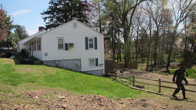 219 Forest St, East Hartford, CT 06118 - view of home's exterior featuring a chimney and a wall unit AC