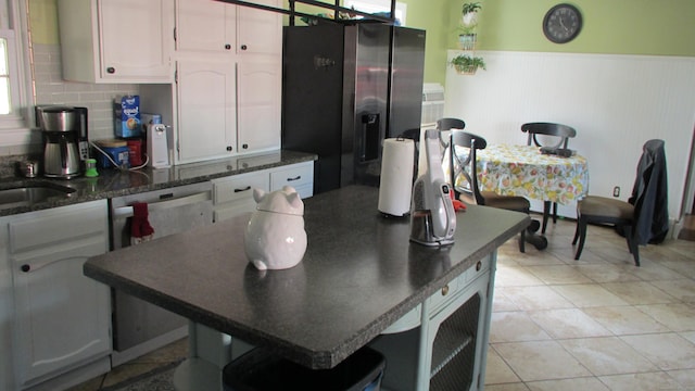 219 Forest St, East Hartford, CT 06118 - kitchen with stainless steel appliances, dark countertops, a wainscoted wall, white cabinetry, and tasteful backsplash