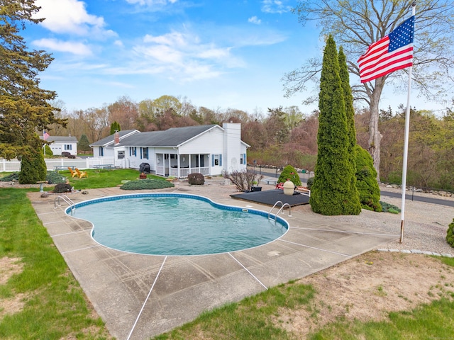 outdoor pool with fence, a patio, and a yard