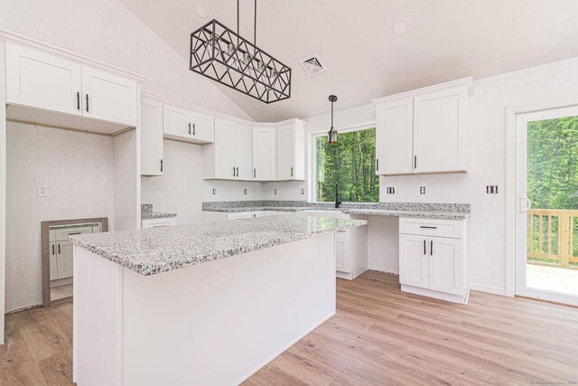 180 Tripp Hollow Rd, Brooklyn, CT 06234 - kitchen with lofted ceiling, light wood-style flooring, white cabinetry, a kitchen island, and a sink