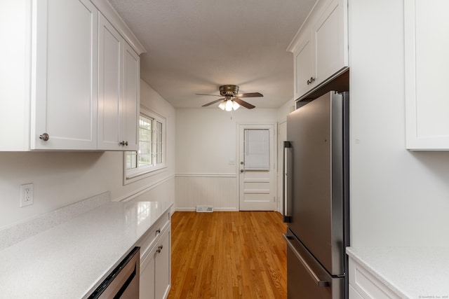kitchen featuring ceiling fan, visible vents, light countertops, white cabinets, and freestanding refrigerator