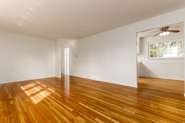 spare room with a ceiling fan, visible vents, and light wood-type flooring