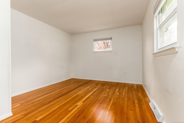 unfurnished room with baseboards, wood-type flooring, and visible vents