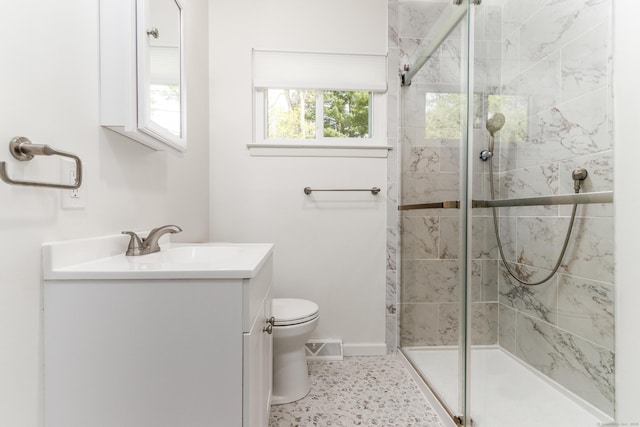 full bath featuring vanity, baseboards, a stall shower, and toilet