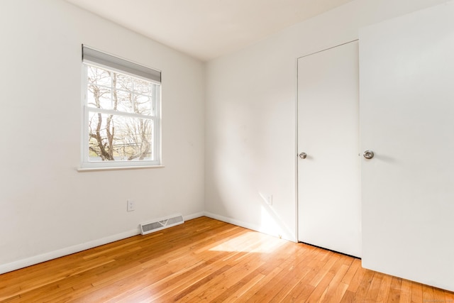 unfurnished bedroom featuring light wood-style floors, baseboards, and visible vents