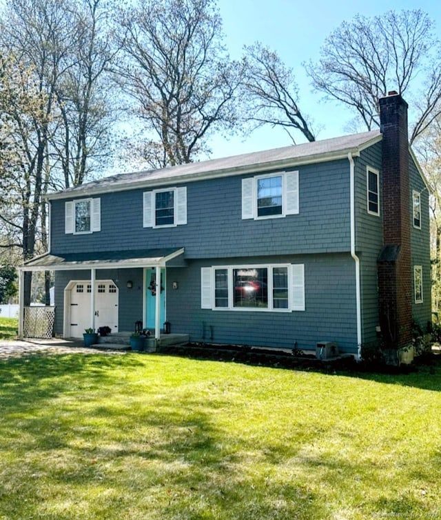 view of front facade with an attached garage, a chimney, and a front lawn