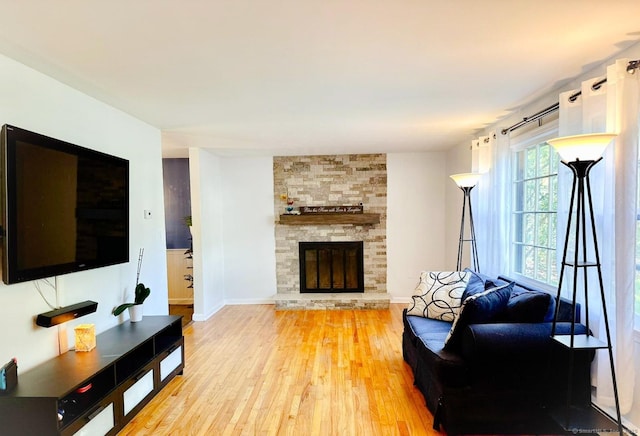 living area featuring wood finished floors, a fireplace, and baseboards