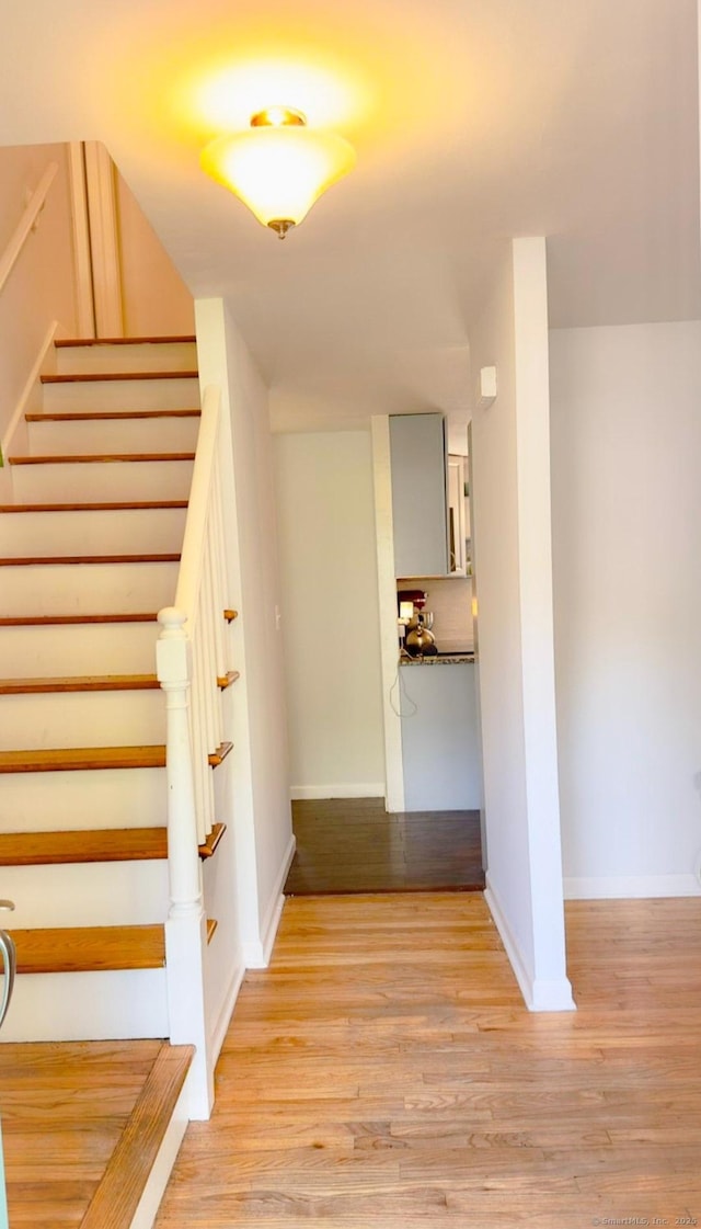 staircase with wood finished floors and baseboards