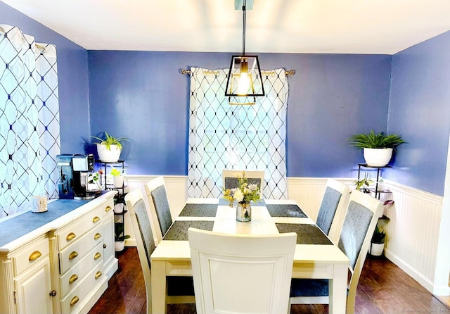 dining room featuring a wainscoted wall and dark wood-style floors