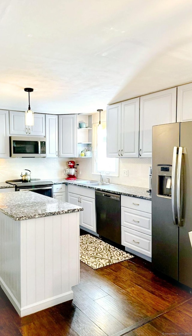 kitchen featuring stainless steel appliances, dark wood-style flooring, light stone countertops, hanging light fixtures, and white cabinets