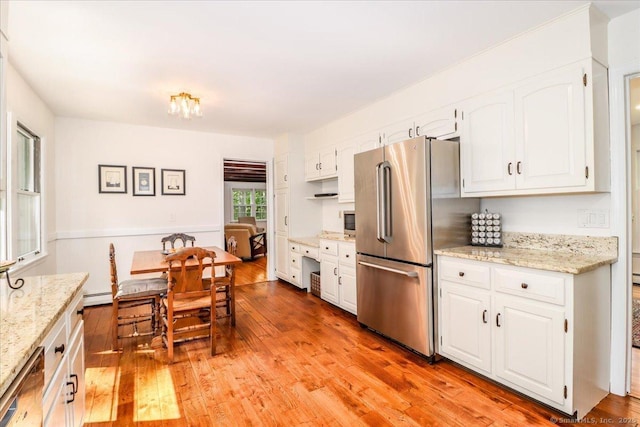12 Winding Brook Ln, Redding, CT 06896 - kitchen featuring appliances with stainless steel finishes, light wood-type flooring, white cabinetry, baseboard heating, and light stone countertops