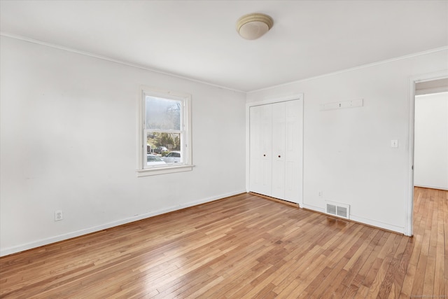 unfurnished room with ornamental molding, visible vents, baseboards, and light wood-style floors