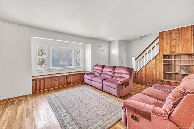 living room with visible vents, stairway, hardwood / wood-style flooring, and baseboards