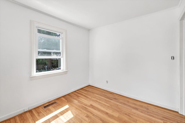 spare room with visible vents, ornamental molding, and light wood-style flooring