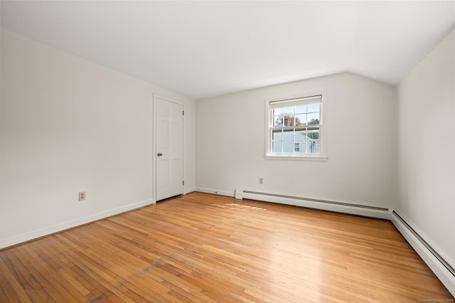 unfurnished room with baseboards, light wood-style flooring, lofted ceiling, and a baseboard heating unit