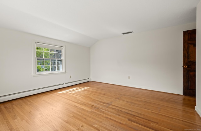 unfurnished room with visible vents, light wood finished floors, lofted ceiling, and baseboard heating