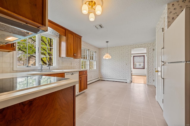 kitchen with brown cabinets, a sink, white appliances, light countertops, and wallpapered walls