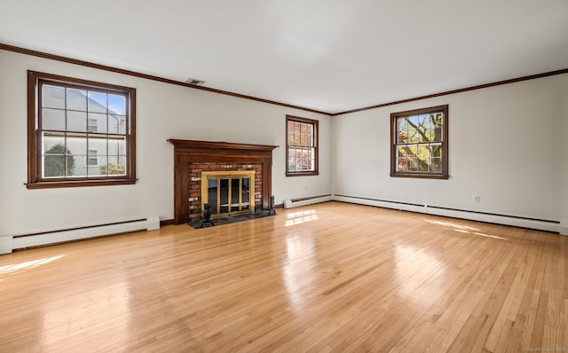 unfurnished living room featuring plenty of natural light, ornamental molding, and light wood finished floors