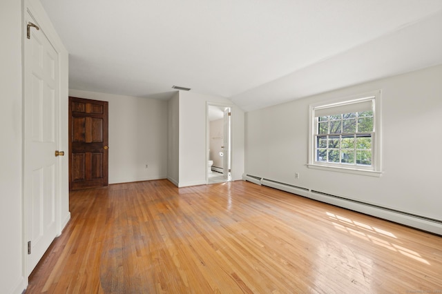spare room with light wood-type flooring, a baseboard radiator, lofted ceiling, and visible vents