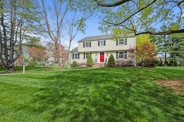 colonial house with a front lawn and a chimney