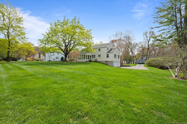 view of yard featuring an attached garage and driveway