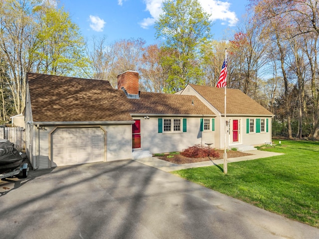 view of front of home featuring a garage, a chimney, driveway, a front yard, and roof with shingles