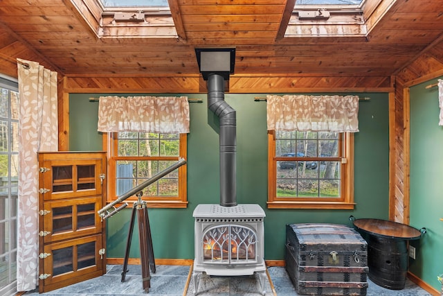detailed view of a skylight, wooden ceiling, a wood stove, and baseboards