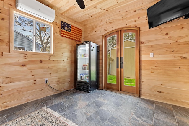 doorway featuring a wall unit AC, stone tile floors, wooden walls, wooden ceiling, and a ceiling fan
