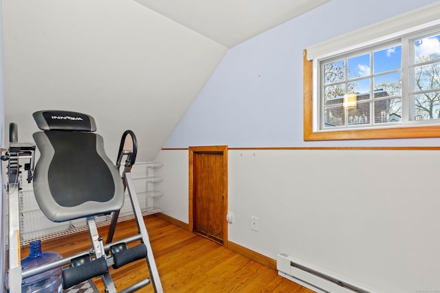 exercise area with a baseboard heating unit, lofted ceiling, light wood-type flooring, and baseboards