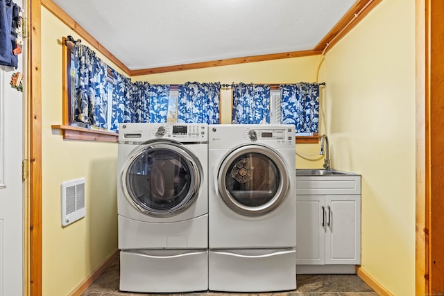 laundry area with washer and clothes dryer, cabinet space, baseboards, and heating unit