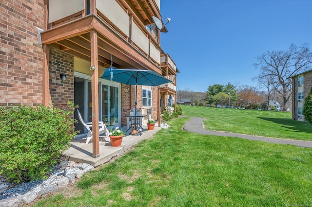 view of yard with a balcony and a patio