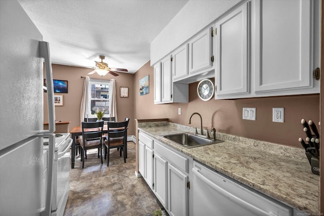 kitchen featuring a sink, ceiling fan, white appliances, light countertops, and a textured ceiling