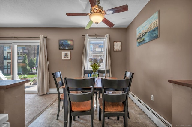 dining room featuring a baseboard radiator, ceiling fan, and baseboards