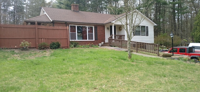 single story home featuring a chimney, roof with shingles, a front yard, fence, and brick siding