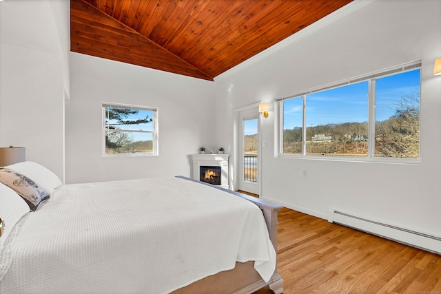 bedroom with wood ceiling, wood finished floors, a baseboard radiator, and multiple windows