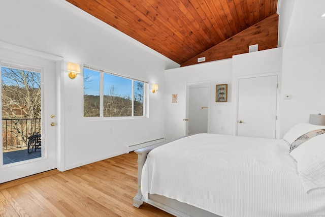 bedroom with a baseboard heating unit, access to outside, multiple windows, and light wood-style flooring