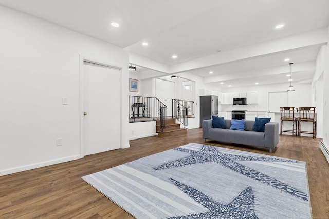 living area featuring recessed lighting, wood finished floors, baseboards, and stairs