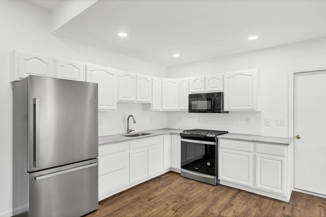 kitchen with a sink, stainless steel appliances, white cabinets, dark wood-style flooring, and recessed lighting