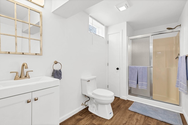 full bathroom featuring toilet, wood finished floors, a stall shower, vanity, and baseboards