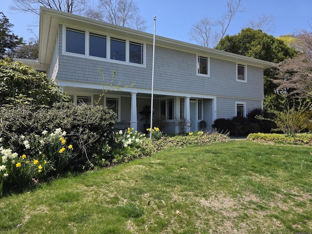 traditional-style home featuring a front lawn