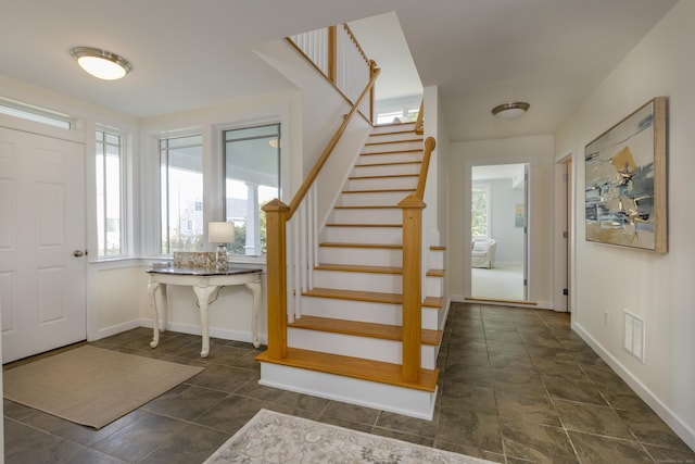 foyer entrance with stairs, visible vents, and baseboards