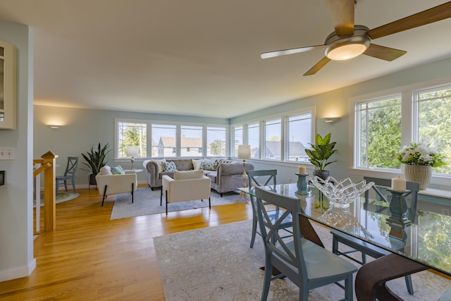 dining area featuring light wood-type flooring, a ceiling fan, and baseboards