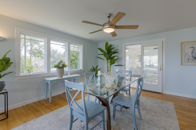 dining space featuring a ceiling fan, wood finished floors, and baseboards