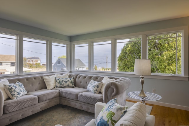 living room featuring baseboards, a healthy amount of sunlight, and dark wood-style floors